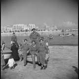 ...mentre in un�altra immagine rappresenta un gruppo di sorridenti commilitoni in posa su un gozzo, tipico natante dei pescatori baresi

(F. Alexander Turnbull Library, Welligton, NZ. Ref. DA-04513-F)